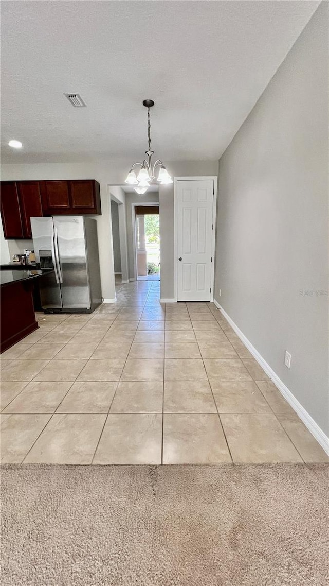 8625 Coventry Park Way, Windermere, FL 34786 - kitchen with stainless steel fridge with ice dispenser, dark countertops, light tile patterned floors, a chandelier, and decorative light fixtures