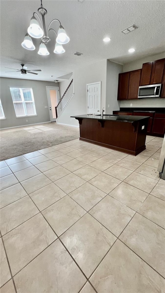 8625 Coventry Park Way, Windermere, FL 34786 - kitchen with stainless steel microwave, dark countertops, open floor plan, a ceiling fan, and a textured ceiling