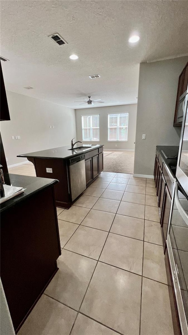 8625 Coventry Park Way, Windermere, FL 34786 - kitchen with appliances with stainless steel finishes, ceiling fan, a textured ceiling, a center island with sink, and dark brown cabinetry