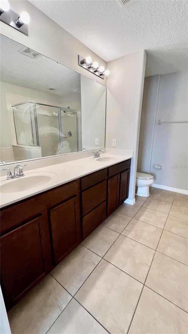 8625 Coventry Park Way, Windermere, FL 34786 - bathroom featuring a shower stall, tile patterned floors, a textured ceiling, and double vanity