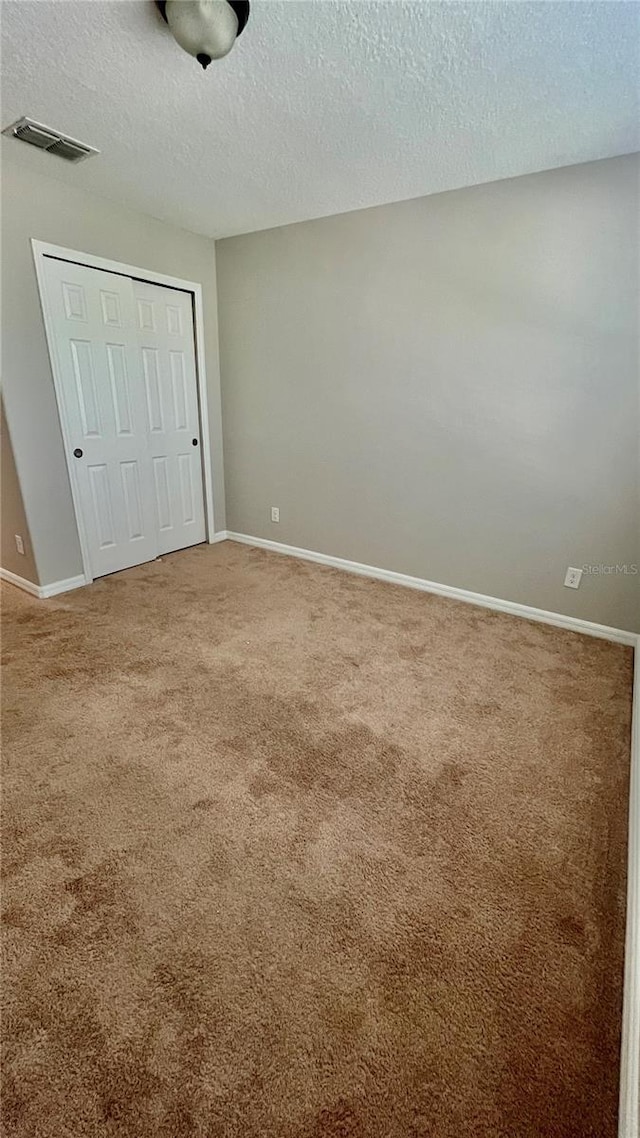 8625 Coventry Park Way, Windermere, FL 34786 - unfurnished bedroom featuring a textured ceiling, a closet, and carpet flooring
