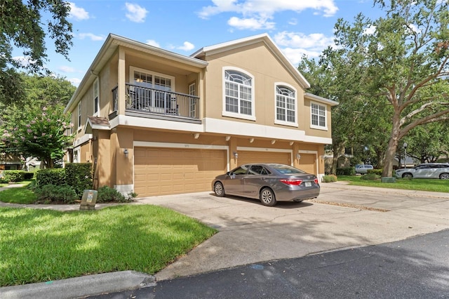 962 Ashworth Overlook Dr Unit C, Apopka, FL 32712 - view of front of property featuring stucco siding, a balcony, a garage, driveway, and a front lawn