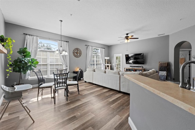 962 Ashworth Overlook Dr Unit C, Apopka, FL 32712 - living area featuring arched walkways, ceiling fan, wood finished floors, and a textured ceiling