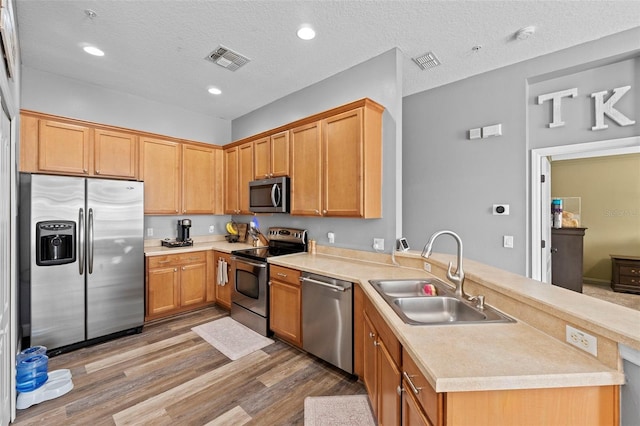 962 Ashworth Overlook Dr Unit C, Apopka, FL 32712 - kitchen featuring appliances with stainless steel finishes, a peninsula, light countertops, wood finished floors, and recessed lighting