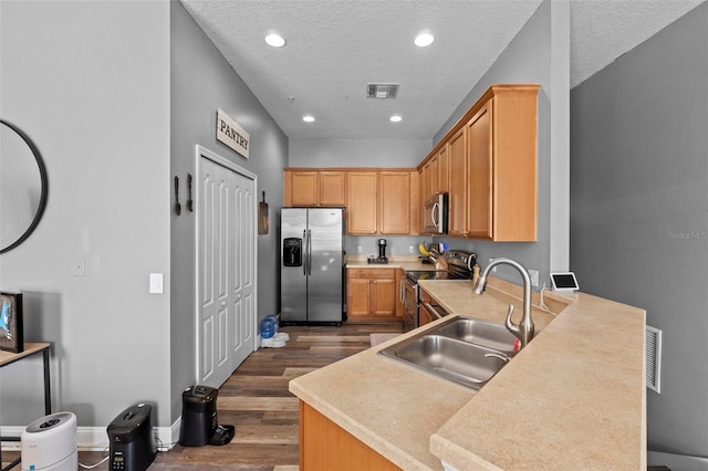 962 Ashworth Overlook Dr Unit C, Apopka, FL 32712 - kitchen featuring appliances with stainless steel finishes, dark wood finished floors, a peninsula, light countertops, and a textured ceiling