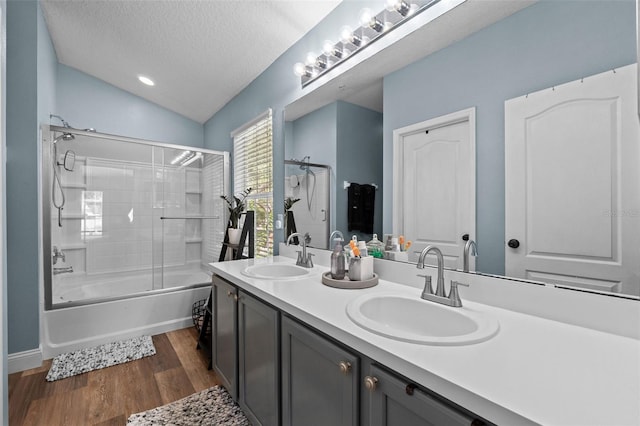 962 Ashworth Overlook Dr Unit C, Apopka, FL 32712 - full bath with double vanity, wood finished floors, combined bath / shower with glass door, lofted ceiling, and a textured ceiling