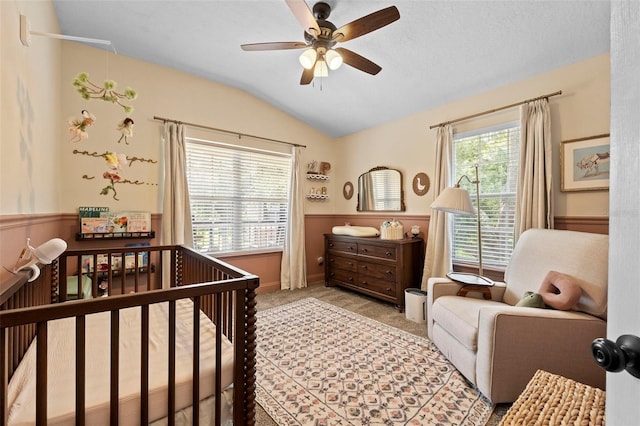 962 Ashworth Overlook Dr Unit C, Apopka, FL 32712 - bedroom with vaulted ceiling, light carpet, a nursery area, wainscoting, and ceiling fan