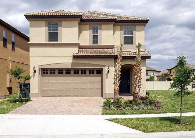8874 Qin Loop, Kissimmee, FL 34747 - mediterranean / spanish home with a garage, decorative driveway, stucco siding, and a tile roof