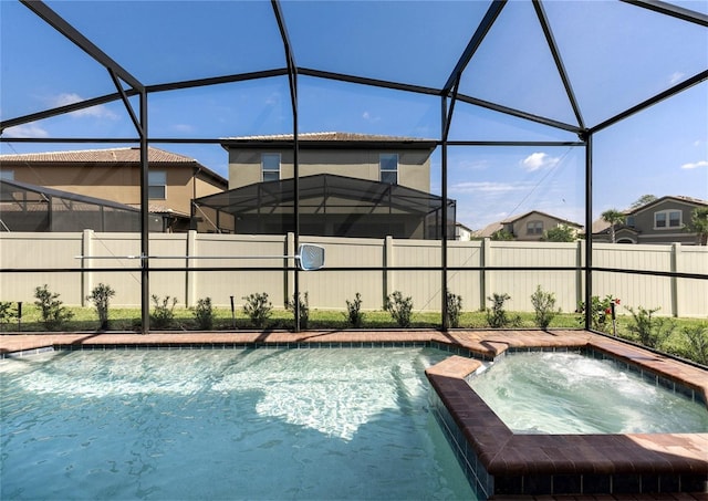 8874 Qin Loop, Kissimmee, FL 34747 - view of pool with glass enclosure, a pool with connected hot tub, and a fenced backyard