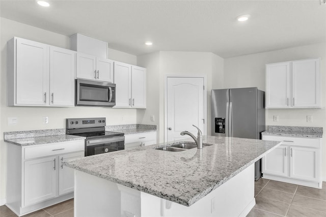 1850 Walnut Creek Dr, Kissimmee, FL 34744 - kitchen featuring stainless steel appliances, white cabinets, light stone countertops, an island with sink, and recessed lighting