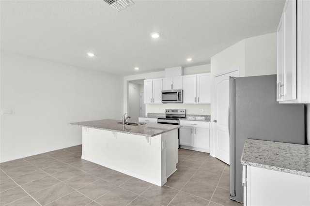 1850 Walnut Creek Dr, Kissimmee, FL 34744 - kitchen featuring stainless steel appliances, white cabinets, a kitchen breakfast bar, light tile patterned floors, and recessed lighting