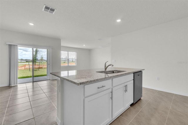1850 Walnut Creek Dr, Kissimmee, FL 34744 - kitchen featuring dishwasher, light stone counters, light tile patterned flooring, an island with sink, and white cabinets