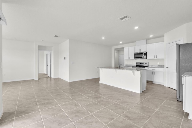 1850 Walnut Creek Dr, Kissimmee, FL 34744 - kitchen with appliances with stainless steel finishes, recessed lighting, a kitchen island with sink, light tile patterned floors, and a kitchen bar