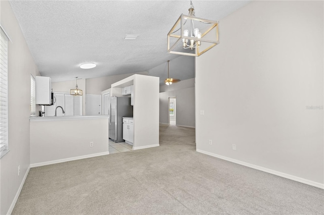 3388 Cypress Point Cir, Saint Cloud, FL 34772 - unfurnished living room with a chandelier, light colored carpet, vaulted ceiling, and a textured ceiling
