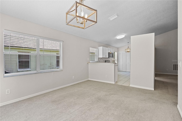 3388 Cypress Point Cir, Saint Cloud, FL 34772 - unfurnished living room with a chandelier, light carpet, vaulted ceiling, and a textured ceiling