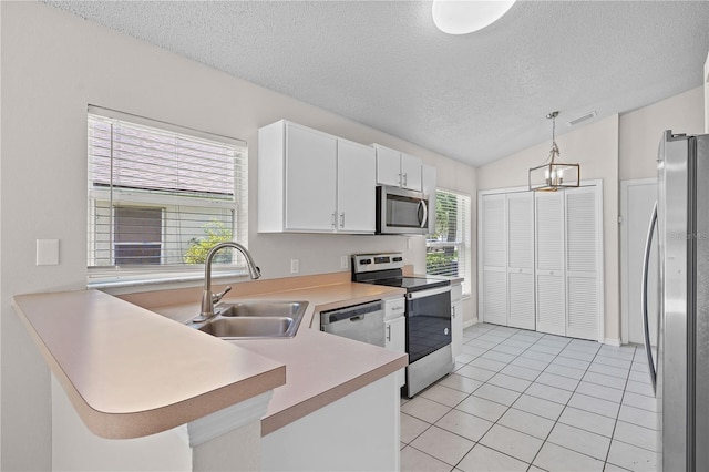 3388 Cypress Point Cir, Saint Cloud, FL 34772 - kitchen with stainless steel appliances, a textured ceiling, light tile patterned floors, light countertops, and a peninsula