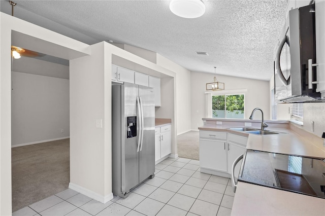 3388 Cypress Point Cir, Saint Cloud, FL 34772 - kitchen with appliances with stainless steel finishes, light carpet, a textured ceiling, light tile patterned floors, and white cabinets