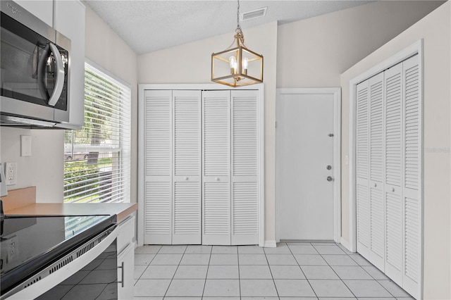 3388 Cypress Point Cir, Saint Cloud, FL 34772 - kitchen with appliances with stainless steel finishes, a chandelier, hanging light fixtures, light tile patterned floors, and light countertops