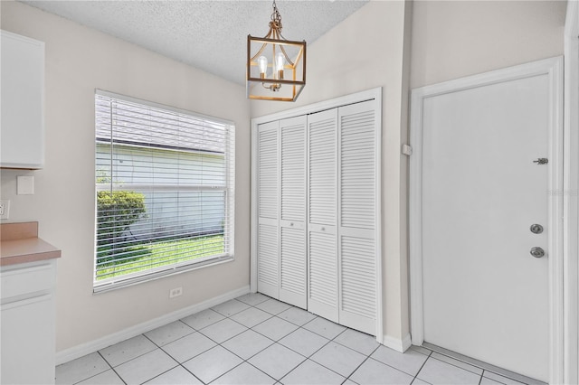 3388 Cypress Point Cir, Saint Cloud, FL 34772 - unfurnished dining area featuring a chandelier, a textured ceiling, and light tile patterned floors