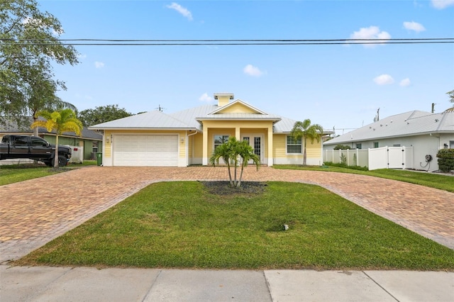 2912 SW Savona Blvd, Port St Lucie, FL 34953 - view of front facade with decorative driveway, a garage, a metal roof, and a standing seam roof