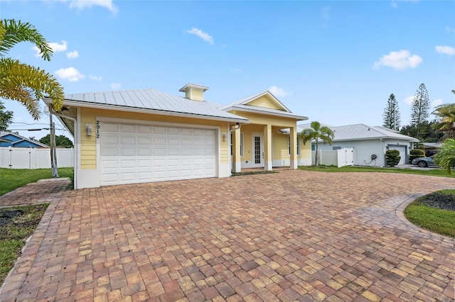 2912 SW Savona Blvd, Port St Lucie, FL 34953 - view of front of house featuring decorative driveway, an attached garage, and a metal roof
