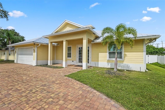 2912 SW Savona Blvd, Port St Lucie, FL 34953 - view of front of home featuring a garage, a metal roof, and decorative driveway