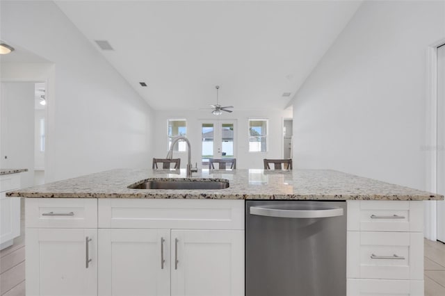 2912 SW Savona Blvd, Port St Lucie, FL 34953 - kitchen featuring stainless steel dishwasher, lofted ceiling, a ceiling fan, light stone counters, and white cabinetry
