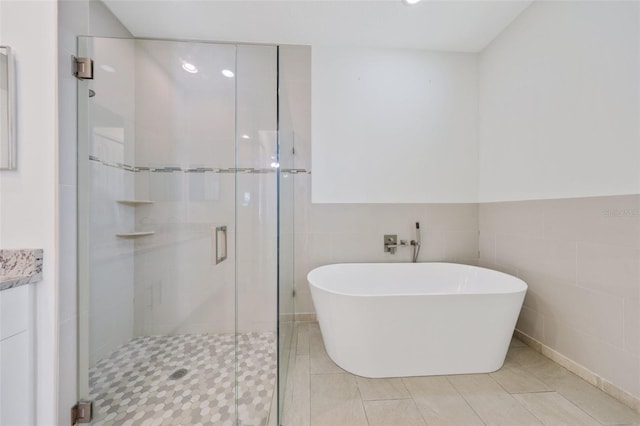 2912 SW Savona Blvd, Port St Lucie, FL 34953 - full bath with a freestanding tub, a shower stall, tile walls, and tile patterned floors