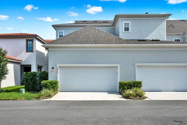 7412 Estuary Lake Loop, Celebration, FL 34747 - view of front facade with stucco siding, roof with shingles, and driveway
