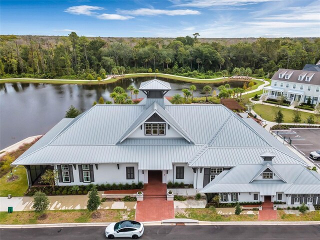 7412 Estuary Lake Loop, Celebration, FL 34747 - view of front of property with a standing seam roof, a wooded view, a water view, and a metal roof