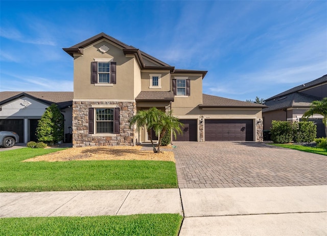9379 Royal Estates Blvd, Orlando, FL 32836 - traditional-style house featuring stone siding, stucco siding, decorative driveway, a front yard, and a garage