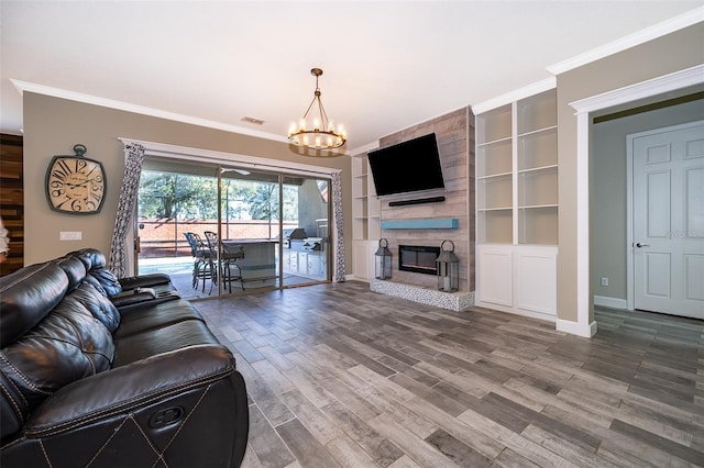 9379 Royal Estates Blvd, Orlando, FL 32836 - living room featuring ornamental molding, wood finished floors, a chandelier, built in shelves, and a fireplace