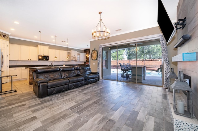 9379 Royal Estates Blvd, Orlando, FL 32836 - living room with a chandelier, light wood-style flooring, ornamental molding, and recessed lighting