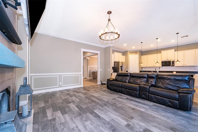 9379 Royal Estates Blvd, Orlando, FL 32836 - living room with a chandelier, wood finished floors, ornamental molding, wainscoting, and a decorative wall