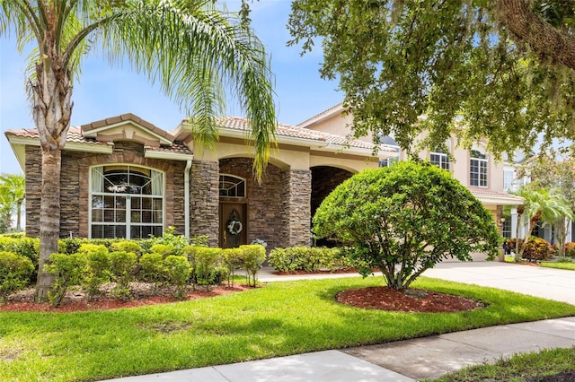 1331 Marble Crest Way, Winter Garden, FL 34787 - view of front of property featuring a front yard, driveway, stone siding, and a tiled roof