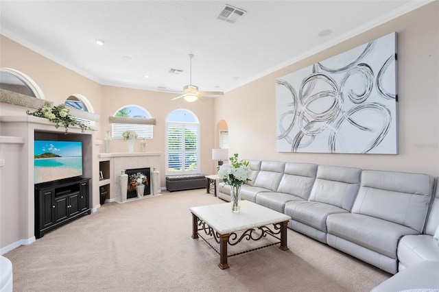 1331 Marble Crest Way, Winter Garden, FL 34787 - living room with carpet flooring, crown molding, a tiled fireplace, ceiling fan, and arched walkways