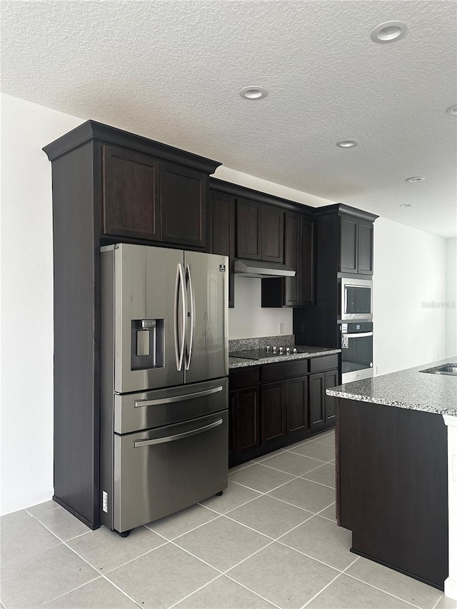 14099 Lochend Way, Winter Garden, FL 34787 - kitchen featuring stainless steel appliances, light stone countertops, light tile patterned flooring, a textured ceiling, and under cabinet range hood