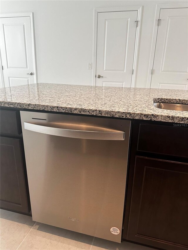 14099 Lochend Way, Winter Garden, FL 34787 - kitchen view of stainless steel dishwasher, light stone counters, and dark brown cabinets