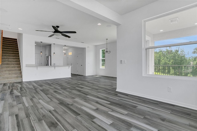 17458 Chateau Pine Way, Clermont, FL 34711 - unfurnished living room featuring stairway, wood finished floors, a ceiling fan, recessed lighting, and a chandelier