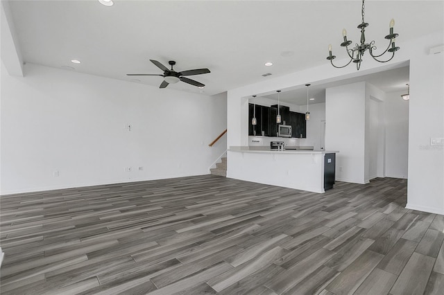 17458 Chateau Pine Way, Clermont, FL 34711 - unfurnished living room featuring a chandelier, wood finished floors, a ceiling fan, recessed lighting, and stairs