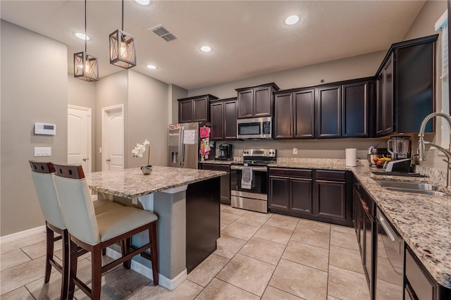 4024 Blazewater Ct, Eustis, FL 32736 - kitchen with appliances with stainless steel finishes, a center island, light tile patterned flooring, a breakfast bar, and light stone counters