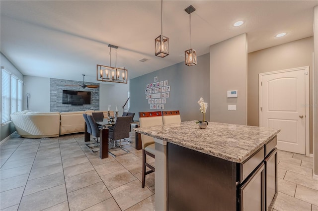 4024 Blazewater Ct, Eustis, FL 32736 - kitchen featuring open floor plan, a kitchen island, hanging light fixtures, light stone counters, and light tile patterned floors