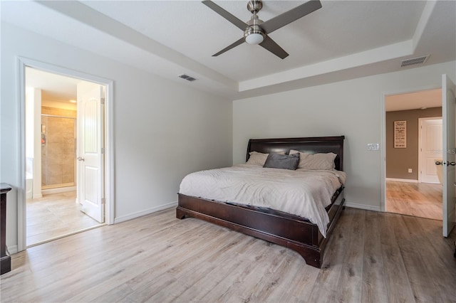 4024 Blazewater Ct, Eustis, FL 32736 - bedroom with a tray ceiling, wood finished floors, ensuite bath, and ceiling fan