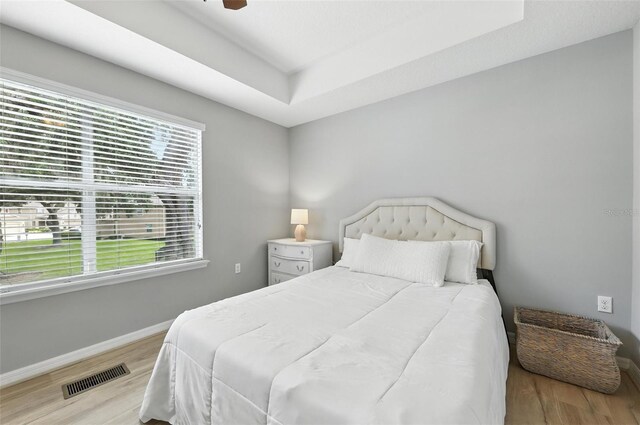 1551 Scarlet Oak Loop Unit B, Winter Garden, FL 34787 - bedroom featuring wood finished floors, a tray ceiling, and a ceiling fan