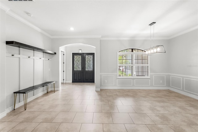 32619 View Haven Ln, Sorrento, FL 32776 - entrance foyer featuring arched walkways, crown molding, a decorative wall, light tile patterned floors, and wainscoting