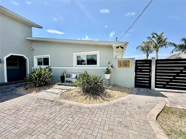 142 Reef Rd, South Daytona, FL 32119 - view of front of home with a gate and stucco siding
