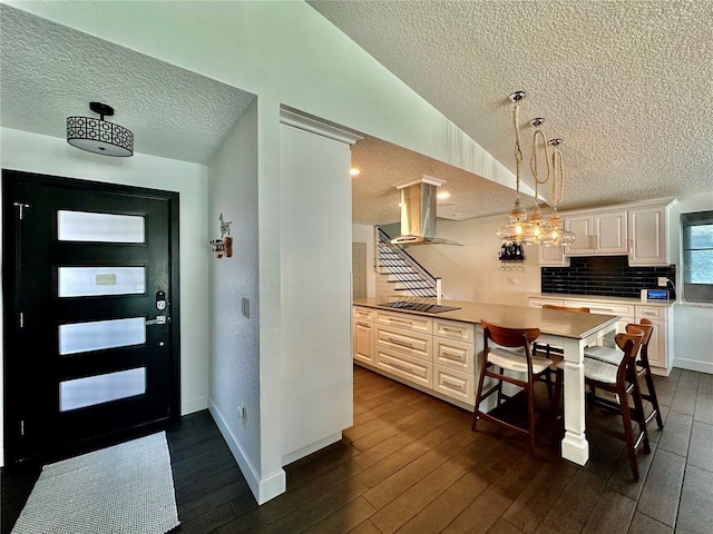 142 Reef Rd, South Daytona, FL 32119 - kitchen with island range hood, a textured ceiling, black electric stovetop, backsplash, and white cabinets