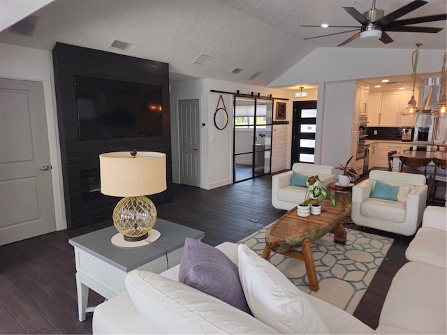 142 Reef Rd, South Daytona, FL 32119 - living area featuring a barn door, a ceiling fan, dark wood finished floors, lofted ceiling, and a textured ceiling