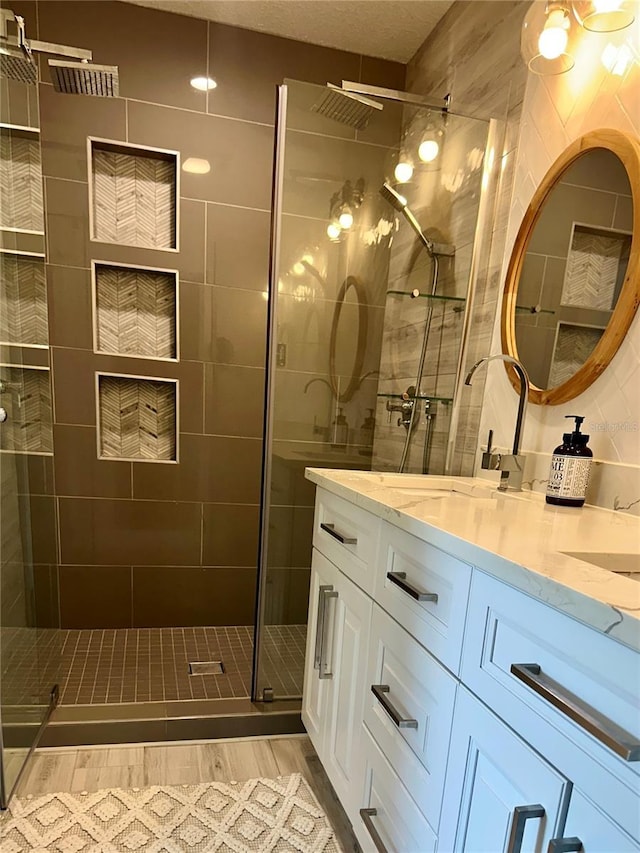 142 Reef Rd, South Daytona, FL 32119 - bathroom featuring wood finished floors, a stall shower, and double vanity