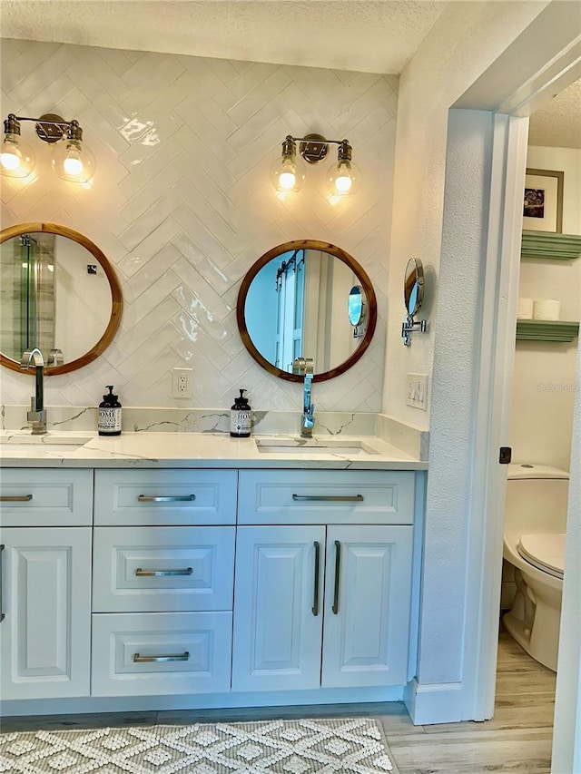 142 Reef Rd, South Daytona, FL 32119 - full bathroom featuring double vanity, backsplash, a textured ceiling, and wood finished floors